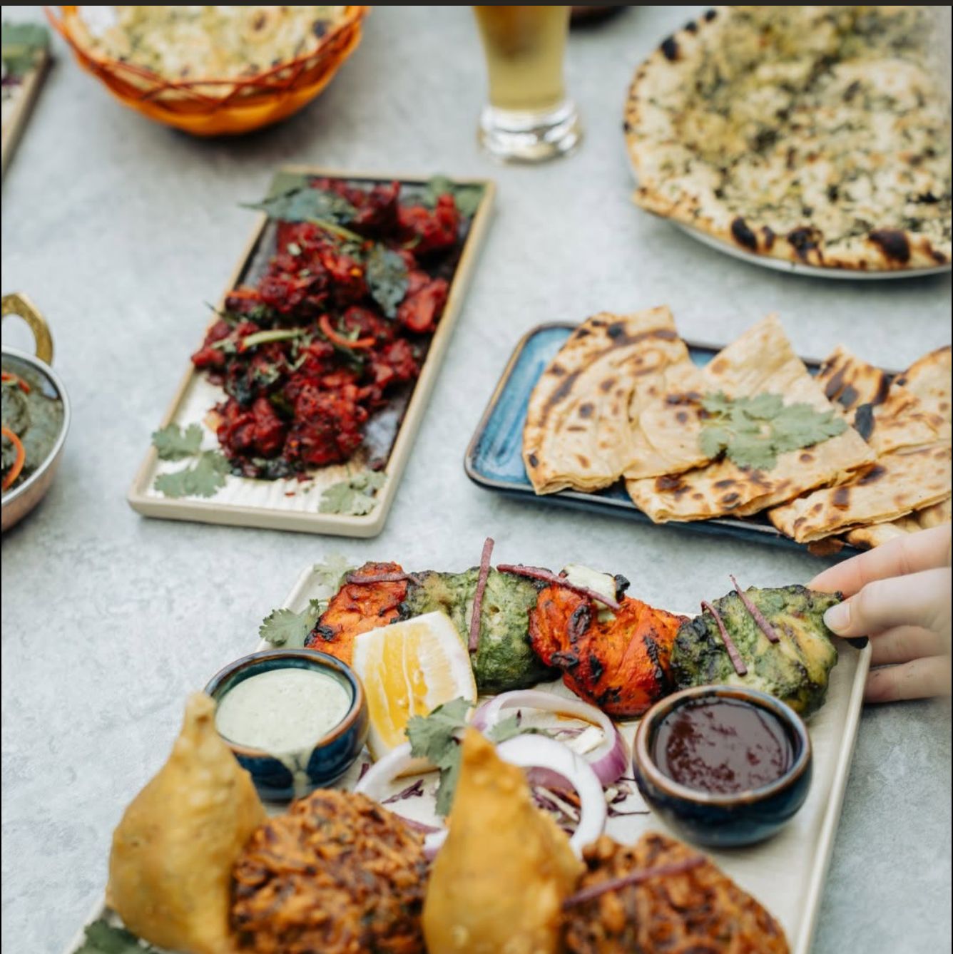 Shared platter of kebabs, samosas and naan