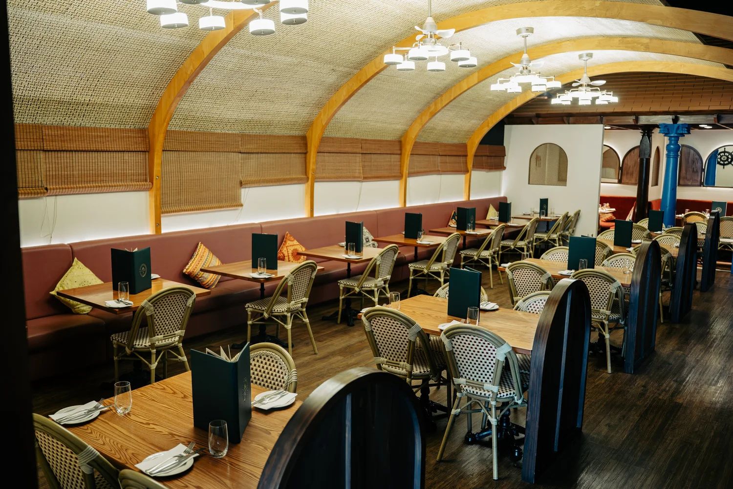 Main dining hall with timber arches and rattan chairs