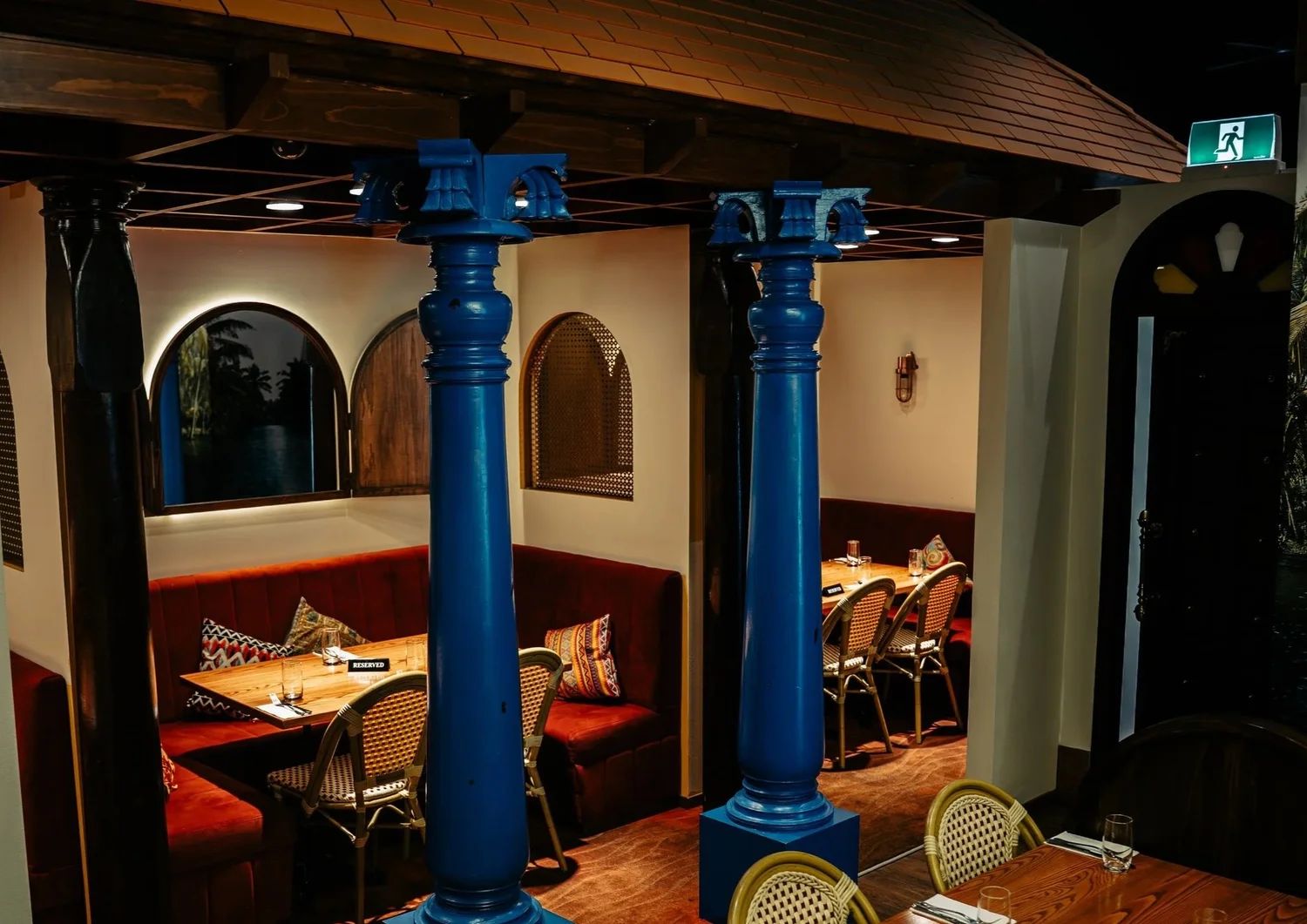 The Mehfil Space with velvet booth seating and blue columns